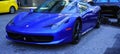 Luxury Ferrari blue car parked at the entrance of the Fairmont Pacific Rim hotel in Downtown Vancouver.