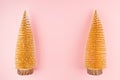 Luxury festive christmas background - two decorative glittering golden christmas trees on soft light pastel pink backdrop, top. Royalty Free Stock Photo