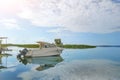 Luxury fishing motor boat moored at coast in bay on river or lake. Scenic blue sky with fluffy white clouds on Royalty Free Stock Photo