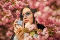 Luxury fragrance. Fashionable woman hold perfume bottle. Cherry blossom aroma. Female perfume. Spring perfume. Fancy Royalty Free Stock Photo