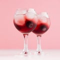 Luxury fresh cold red summer fruit cocktails with ice cubes, blueberry in elegant modern kitchen interior in soft pastel pink. Royalty Free Stock Photo