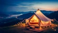 Luxury glamping camping tent with cozy accessories, light garlands and beautiful landscape