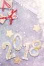 Luxury glitter numbers 2018 with keyboard and presents under snow on grey concrete background