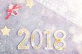 Luxury glitter numbers 2018 in a row with keyboard and presents under snow on grey concrete background Royalty Free Stock Photo