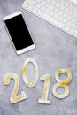 Luxury glowing numbers 2018 with cell phone and keyboard on grey background