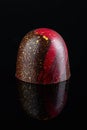 Luxury handmade bonbon decorated with gold and red paint on black background Royalty Free Stock Photo