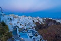 Luxury holiday resort clifftop villas overlooking the Caldera on twilight Santorini Greece