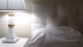 Luxury hotel bed, getting ready for bed, bedside table with lamp and clean white bed linen on the bed with pillow Royalty Free Stock Photo