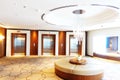 Luxury hotel lobby or hall with three modern elevators and glass chandelier in the middle Royalty Free Stock Photo