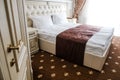 Luxury hotel room at tourist retreat. Entering the suite, door open and bed in the background. Elegant vintage decor for luxurious Royalty Free Stock Photo