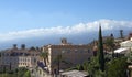 Luxury hotels and famous Etna volcano in white clouds in the background. Scenic landscape view of Taormina, Sicily Royalty Free Stock Photo