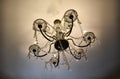 luxury interior details. chandelier with glowing lamp and sparkling crystal pendant hangings. Vintage lamp on ceiling