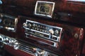 Luxury interior of old classic American car. Wooden decorated dashboard with radio and clocks. Royalty Free Stock Photo