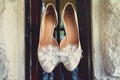 Luxury ivory wedding shoes with lace flower on it, for bride, selective focus.