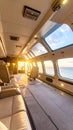 Luxury Jet Interior with Leather Seats Flying Over Ocean at Sunset, Private Plane with Panoramic Windows and Sky Royalty Free Stock Photo