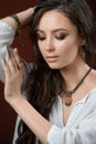 Luxury jewelry and fashion concept. A model with earrings necklace and ring on brown background