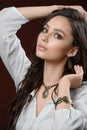 Luxury jewelry and fashion concept. A model with stylish collection - bracelet earrings necklace on brown background