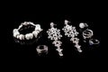 Luxury jewelry set. White gold or silver rings, earrings with crystals and pendant isolated on black. Selective focus. Royalty Free Stock Photo