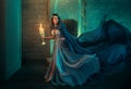 Luxury lady Queen medieval royal dress run escapes from Gothic night castle. Blue silk dress, cloak train plume waving