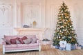 Luxury living room interior with sofa decorated chic Christmas tree, gifts and pillows. Classic interior in pink shades. Christmas