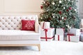 Luxury living room interior with sofa decorated chic Christmas tree, gifts and pillows. Classic interior in red shades. Christmas Royalty Free Stock Photo