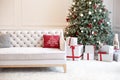 Luxury living room interior with sofa decorated chic Christmas tree, gifts and pillows. Classic interior in red shades. Christmas