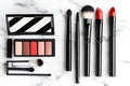Luxury makeup set on marble table: brushes, lipsticks, and eyeshadows for a chic look Royalty Free Stock Photo