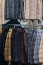 Luxury mink coats. Pink, grey, dark grey, pearl color fur coats on showcase of market. Best gift for a woman. Outerwear. Close up