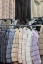 Luxury mink coats. Pink, grey, dark grey, pearl color fur coats on showcase of market. Best gift for a woman. Outerwear. Close up