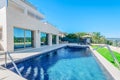 Luxury modern house with swimming pool with waterfall jet. House Royalty Free Stock Photo