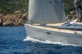 Luxury new cruising sailboat bow with teak deck under hoisted sails.