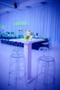 Luxury orchid cocktail flower arrangement on lucite stools and table set up for a party in a ballroom Royalty Free Stock Photo