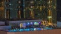 Luxury outdoor swimming pool and relaxing zone around aerial night timelapse