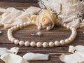 Luxury pearl necklace, ring and earrings with white rose petals, close up