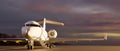 A luxury private jet parked on runway over blurred sunset sky view Royalty Free Stock Photo