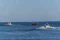 Three boats moving through the blue wather.