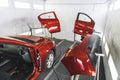 A luxury red car in a paint shop with its doors removed for fresh coat of paint Royalty Free Stock Photo