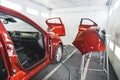 A luxury red car in a paint shop with its doors removed for fresh coat of paint Royalty Free Stock Photo