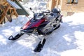 luxury red modern snowmobile scooter vehicle parked on snow in mountains road in cold winter day.rental automobile