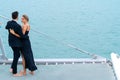 Luxury relaxing couple traveler in nice dress and suite stand and hug in love at part of cruise yacht with background of sea and Royalty Free Stock Photo