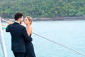 Luxury relaxing couple traveler in nice dress and suite stand and hug in love at part of cruise yacht with background of sea and Royalty Free Stock Photo