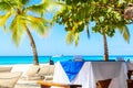 Luxury resort. Empty table for dinner near palm trees on the caribbean tropical beach. Saona Island, Dominican Republic. Vacation Royalty Free Stock Photo