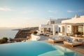 Luxury resort hotel with pool and white house by sea at sunset in summer. Rich mansion with terrace near beach in Greek style. Royalty Free Stock Photo