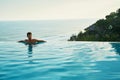 Luxury Resort. Man Relaxing In Swim Pool. Summer Travel Vacation Royalty Free Stock Photo