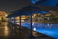 luxury resort with pool at night view. hotel outdoor landscape with pool. Night pool side of rich hotel Royalty Free Stock Photo