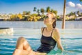 Luxury resort swimming pool. Beautiful woman tourist relaxing in holiday retreat on summer travel vacation. Bikini girl Royalty Free Stock Photo