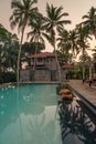 Luxury resort with swimming pool and tropical landscape palm tree at sunset Royalty Free Stock Photo