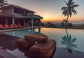 Luxury resort with swimming pool and tropical landscape palm tree at sunset Royalty Free Stock Photo