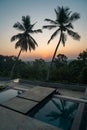 Luxury resort with swimming pool and tropical landscape palm tree at sunset Royalty Free Stock Photo