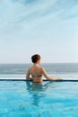 Luxury Resort. Woman Relaxing In Infinity Swimming Pool Water. Beautiful Happy Healthy Female Model Enjoying Summer Travel Vacatio Royalty Free Stock Photo